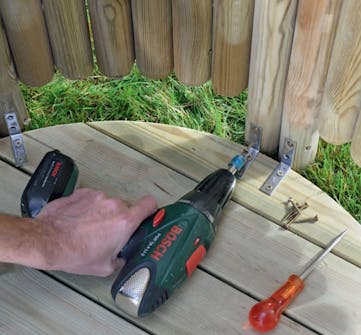 Vægge til udendørs bruser fastgøres i bunden De fire vægsektioner skrues fast på vinkelbeslag i bunden af udendørs bruseren